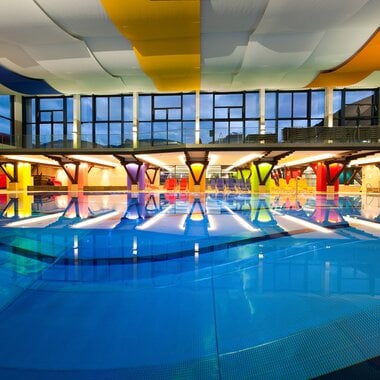 Hallenbad Zell am See – Innenansicht mit Schwimmbecken und farbenfroher Decke