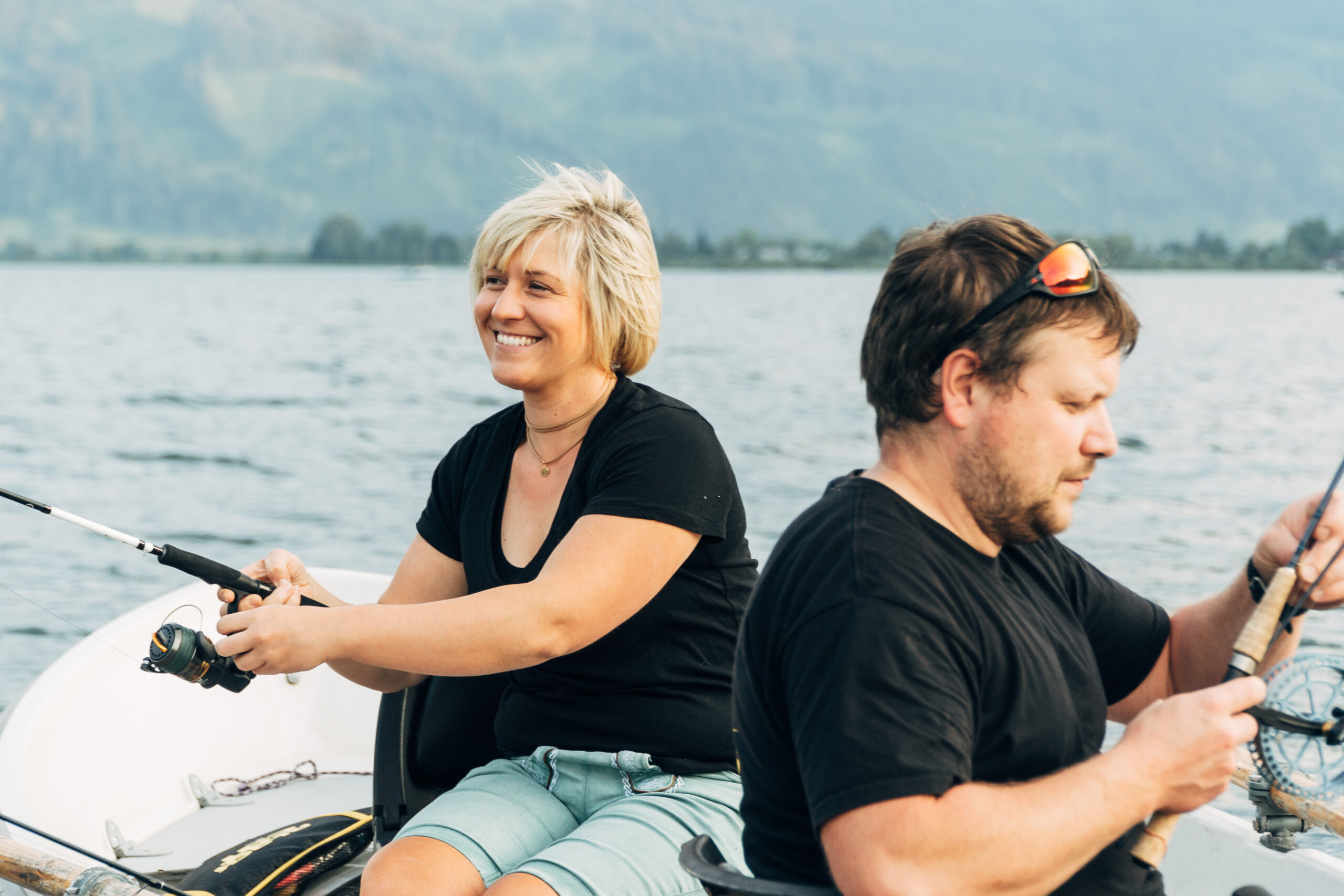 Zwei Angler beim Fischen auf dem Zeller See mit Alpenpanorama im Hintergrund