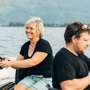 Zwei Angler beim Fischen auf dem Zeller See mit Alpenpanorama im Hintergrund