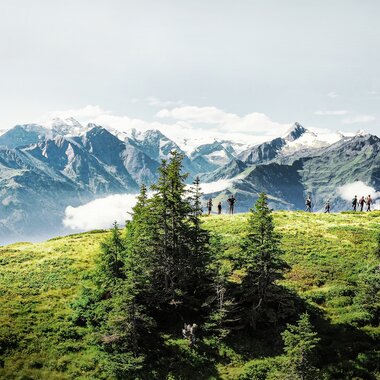Wanderer auf dem Hohe Tauern Panorama Trail mit Blick auf die Alpen und den Zeller See