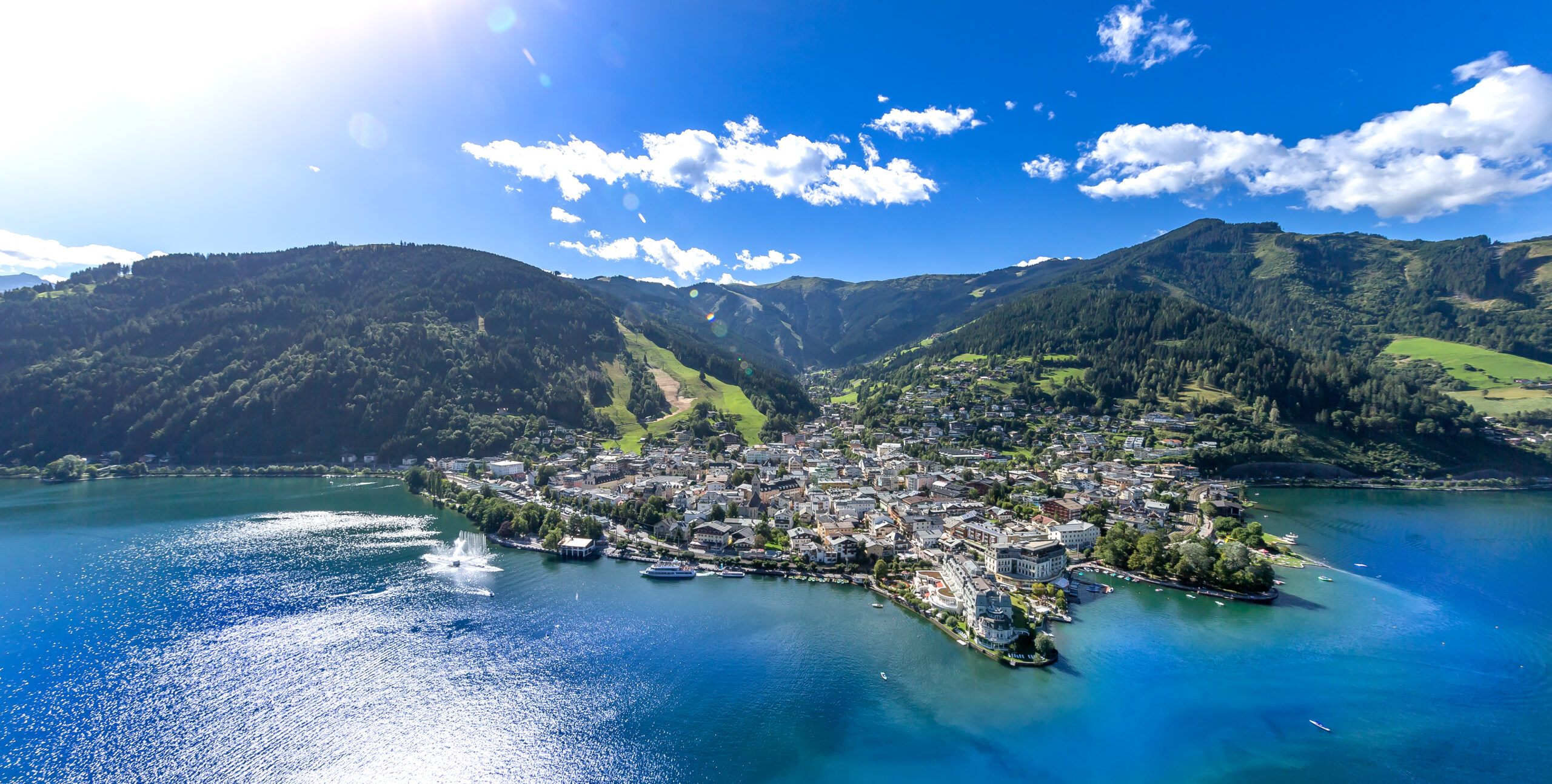 Luftaufnahme von Zell am See mit Stadt, Zeller See und umliegenden Bergen.