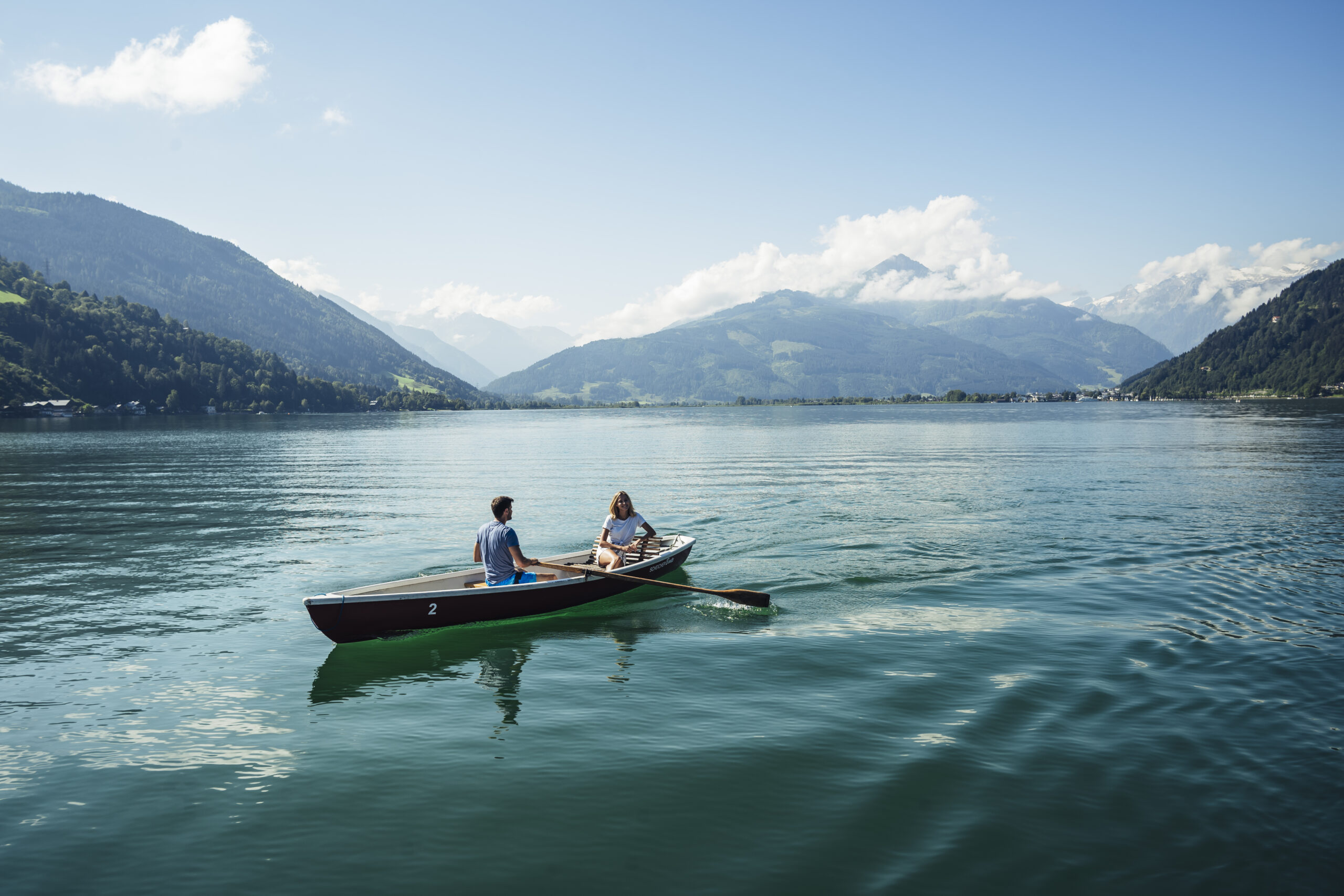 Zwei Personen beim Stand-up Paddleboarding auf dem Zeller See mit Bergpanorama