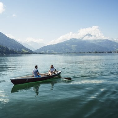 Zwei Personen beim Stand-up Paddleboarding auf dem Zeller See mit Bergpanorama