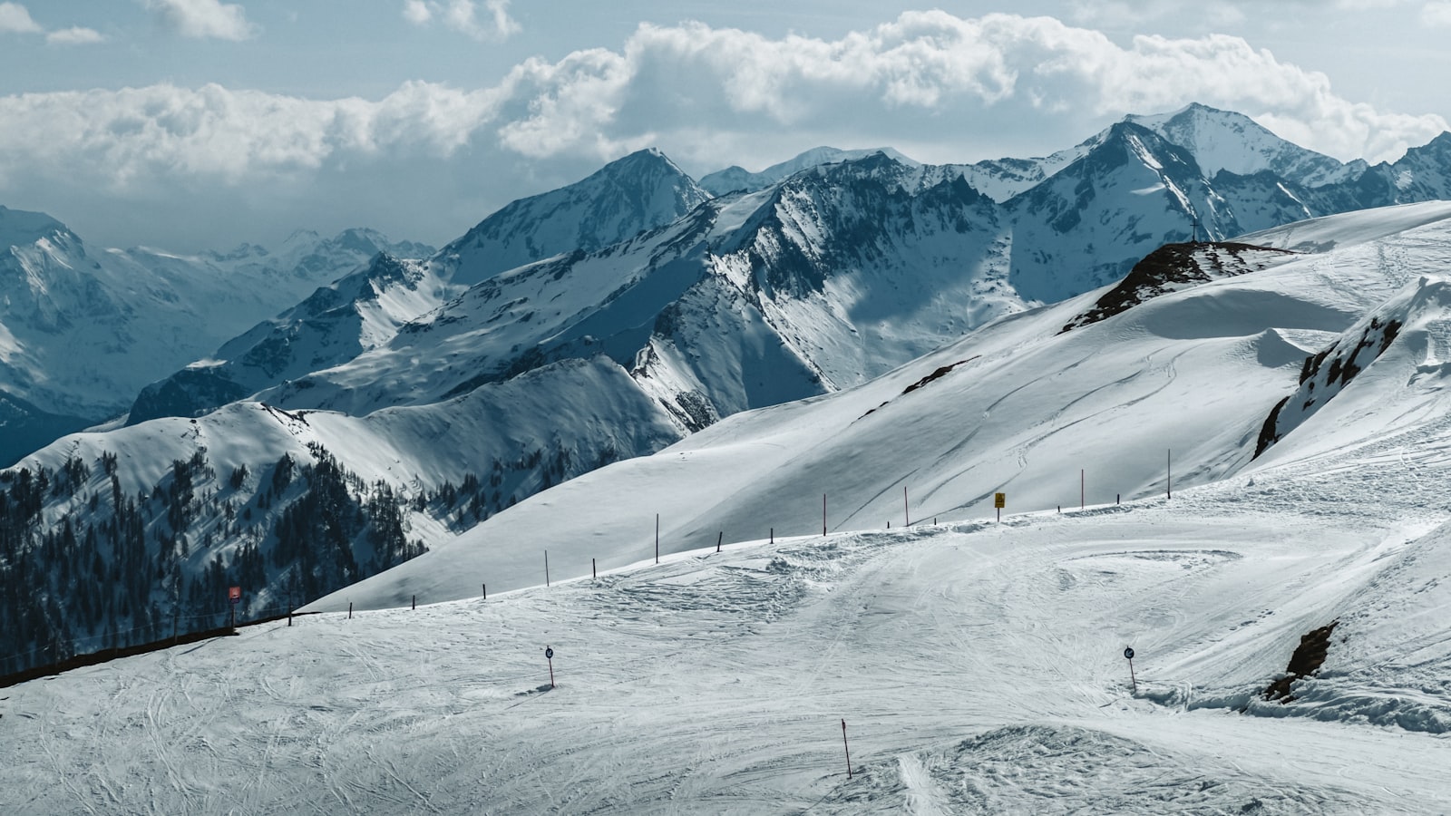 Verschneite Skipiste zwischen hohen Berggipfeln im Salzburger Land